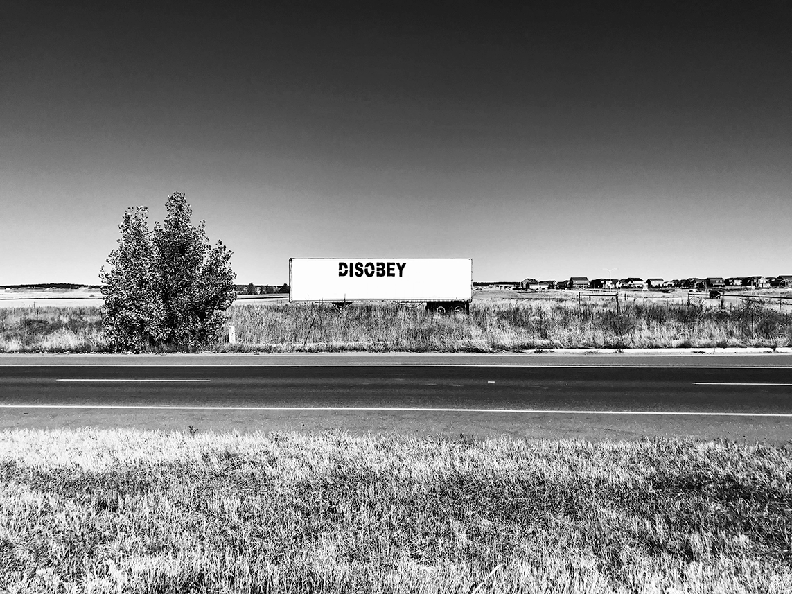 DISOBEY, They Live, We Sleep.  Black and white semi-truck trailer.